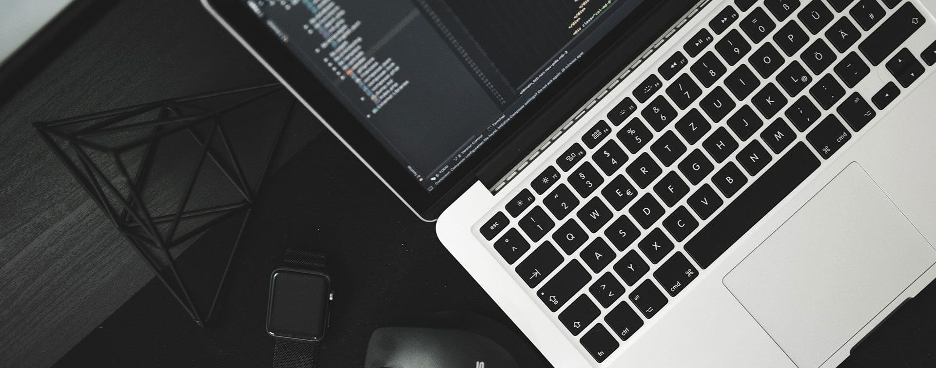 Laptop with code on a dark desk